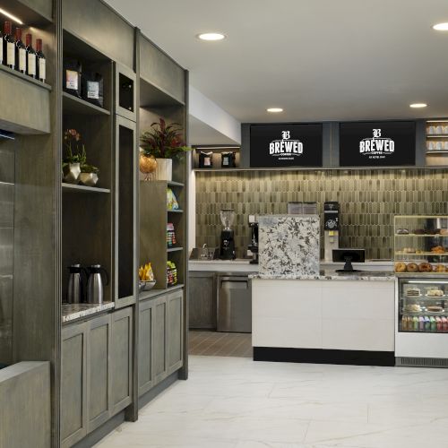 A modern convenience store with well-lit shelves, a refrigerated section on the left, and a clean checkout area at the back.