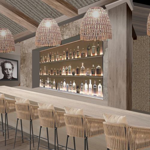 A modern bar with wooden stools, bottle display, wicker light fixtures, and wall art creates a cozy atmosphere.