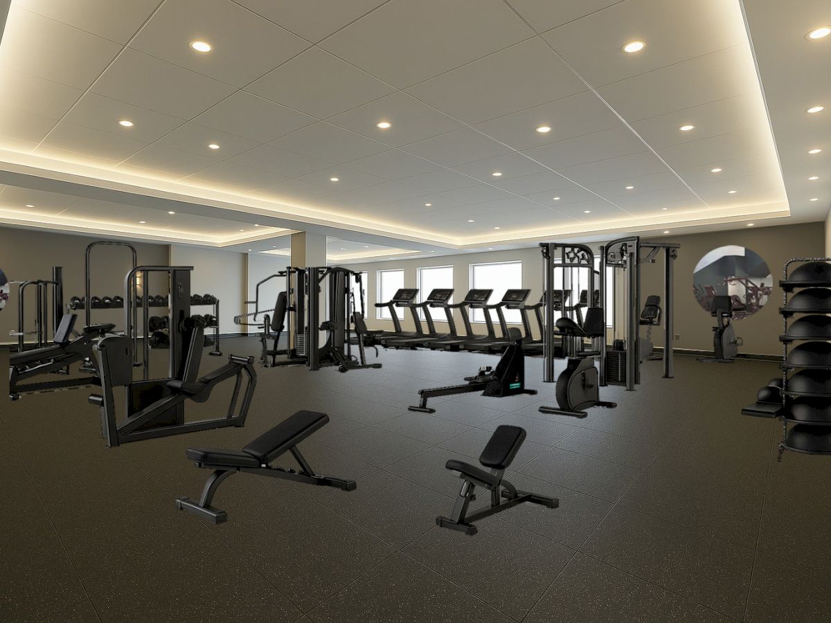 The image shows a spacious gym with various exercise equipment, including treadmills, weights, and benches, in a well-lit room.