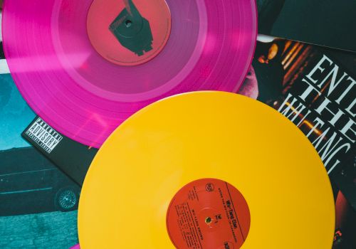 Colorful vinyl records&mdash;pink, yellow, and purple discs on a collage of album art and photos, retro music vibes and grooves all around.