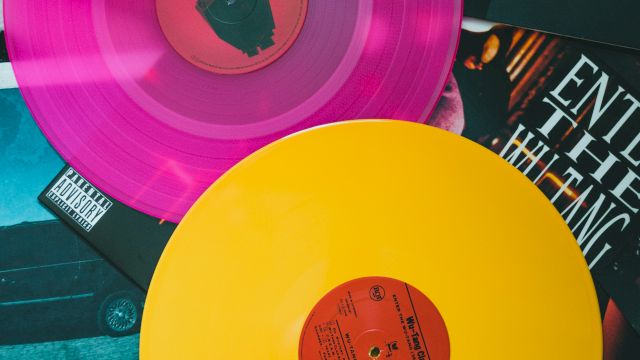 Colorful vinyl records&mdash;pink, yellow, and purple discs on a collage of album art and photos, retro music vibes and grooves all around.