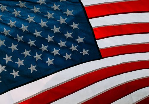 A close-up of the United States flag, with red and white stripes and white stars on a blue field, waving.